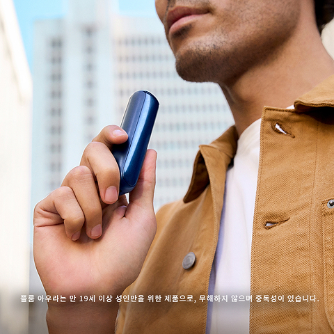 手持藍色 Ploom Aura 的使用情境